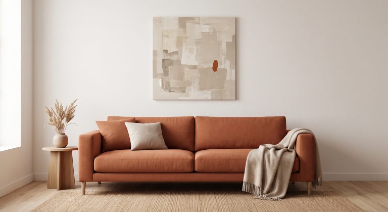 Living room with a warm terracotta sofa and a neutral abstract artwork echoing the terracotta in one small accent