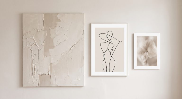 Neutral gallery wall of four artworks in ivory, sand and taupe tones mixing texture, line and photography
